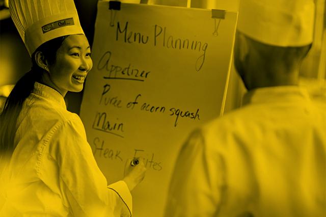 Student in a chef's uniform plans a menu